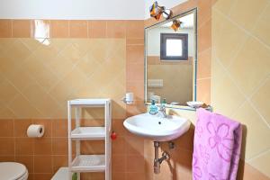 a bathroom with a sink and a toilet and a mirror at Casa Spaziosa in Bari Sardo +28 photos