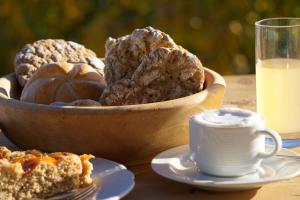 a bowl of bread and a cup of milk on a table at Waalhof Ferienwohnung Mohnblume in Silandro