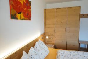 a bedroom with a bed and a cabinet at Waalhof Ferienwohnung Mohnblume in Silandro
