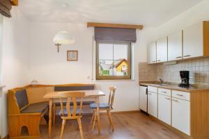 a kitchen with a table and chairs in a room at Ferienwohnungen Hackerhof in Bad Füssing