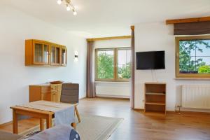 a living room with a table and a tv at Ferienwohnungen Hackerhof in Bad Füssing