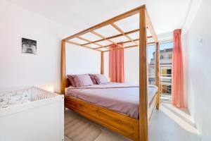 a bedroom with a canopy bed and a window at Casa Rewa in Port d'Alcudia