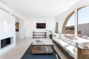 a living room with a white couch and a fireplace at Casa Rewa in Port d'Alcudia