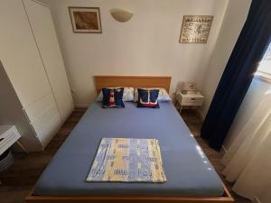 a small bedroom with a blue bed with two pillows at "Ivanera" Postira otok Brač in Postira