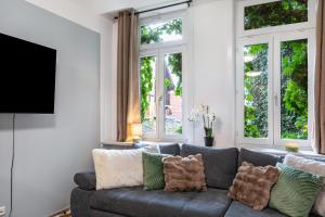 a living room with a gray couch and windows at Marktplatz Ferienwohnung in Alsfeld
