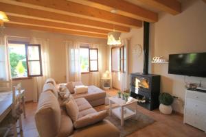 a living room with a couch and a tv at Sa Vinya de Son Bou in Sóller