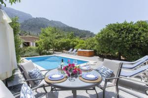 a patio with a table and chairs next to a pool at Sa Vinya de Son Bou in Sóller
