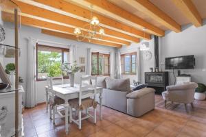 a living room with a table and chairs and a television at Sa Vinya de Son Bou in Sóller