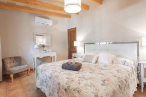 a bedroom with a large bed and a chair at Sa Vinya de Son Bou in Sóller +23 photos