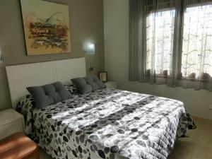 a bedroom with a black and white bed with a window at Villa Rocamar in L'Escala