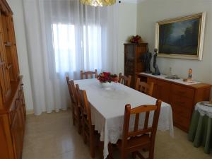 a dining room with a white table and chairs at Villa Rocamar in L'Escala +6 photos