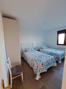 a bedroom with two beds and a chair at Casa Pedro in Vélez-Rubio