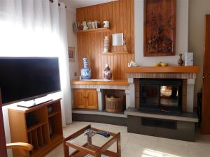 a living room with a television and a fireplace at Villa Rocamar in L'Escala