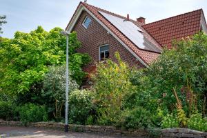 a house with a solar roof and a street light at Inge Huus in Hude
