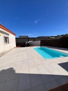 a swimming pool next to a building with a blue at Villa Lucia in Narbonne