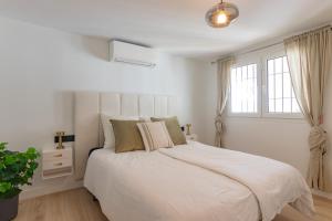a white bedroom with a large bed and a window at Casa Lagos - 046 in Caleta De Velez +20 photos