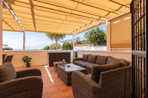 a patio with a couch and chairs and a table at Casa Lagos - 046 in Caleta De Velez