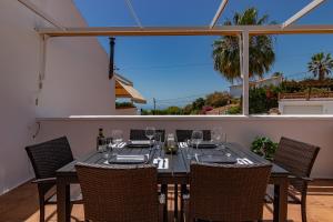 a dining table with chairs on a patio at Casa Lagos - 046 in Caleta De Velez