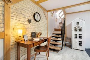 an office with a desk and a clock on a stone wall at Quartier Sängerstadt in Finsterwalde +6 photos