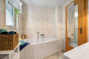 a white bathroom with a tub and a window at Quartier Sängerstadt in Finsterwalde