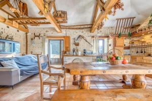 a kitchen and living room with a table and a couch at Le Moulin in Guizengeard