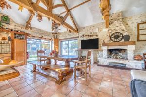 a living room with a table and a fireplace at Le Moulin in Guizengeard