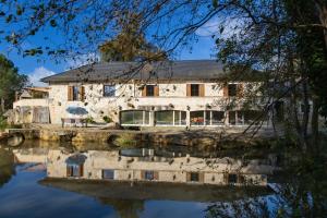 a building next to a body of water at Le Moulin in Guizengeard