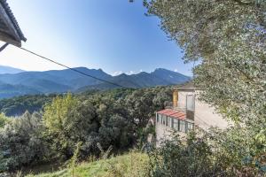 an old house on a hill with mountains in the background at Casa Pirinea in Belsierre