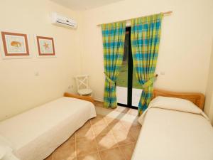 two beds in a room with a window at Sami Beach Villas Dafni in Sami