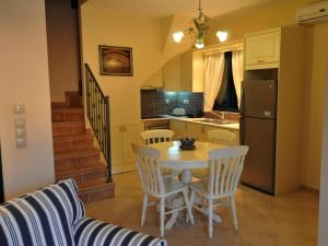 a kitchen with a table and chairs and a kitchen with a refrigerator at Sami Beach Villas Dafni in Sami