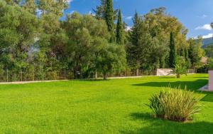 a large yard with green grass and trees at Sami Beach Villas Dafni in Sami
