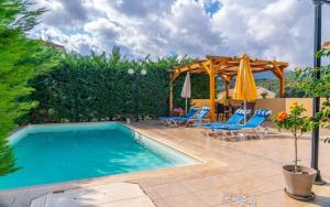 a swimming pool with chairs and umbrellas next to a patio at Sami Beach Villas Dafni in Sami +17 photos