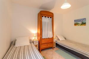 a bedroom with two beds and a dresser in it at Maison de vacances Camille in Artigues