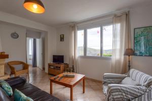 a living room with a couch and a table at Maison de vacances Camille in Artigues