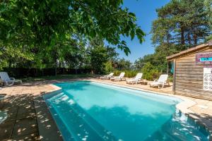 a swimming pool with lounge chairs and a house at Gite Thym in Mirabel-aux-Baronnies