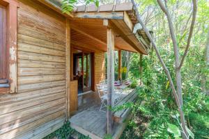 a wooden house with a deck in the woods at Gite Thym in Mirabel-aux-Baronnies