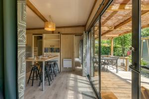 a kitchen and dining area of a house with sliding glass doors at Camping L'imprévu in Vaulnaveys-le-Bas