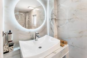 a white bathroom with a sink and a mirror at Doliva Studio Anthi private jacuzzi in Agios Gordios +25 photos