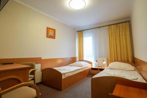 a hotel room with two beds and a desk at Hotel Stadion in Kielce +32 photos