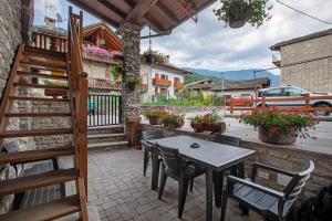 a patio with a table and chairs and a building at Casa Piertor Morgex in Morgex