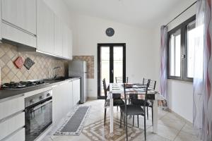 a kitchen with a table and chairs in a kitchen at Casa Spaziosa in Bari Sardo