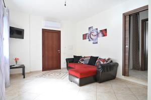 a living room with a red chair and a red couch at Casa Spaziosa in Bari Sardo