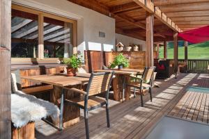 a patio with wooden tables and chairs on a deck at Naturidyll Mitterbach in Rio Bianco