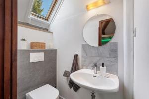 a bathroom with a sink and a mirror at Ferienhaus Rotkäppchen in Frankenau +18 photos
