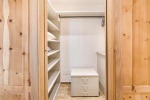 a walk in closet with wood paneling and a stool at Casa Cecilia tra Bormio e Livigno in Valdidentro +14 photos