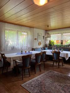 a dining room with tables and chairs and windows at Gästehaus Schoch-Bächle in Bad Rippoldsau-Schapbach