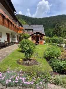 a garden in front of a building with flowers at Gästehaus Schoch-Bächle in Bad Rippoldsau-Schapbach