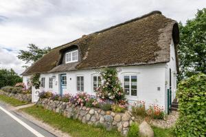 a white cottage with a thatched roof at Mein Haus in Pellworm