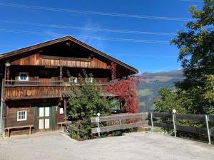 a wooden house with a fence in front of it at Berghaus Wiesegg - Uriges Tiroler in Fügenberg