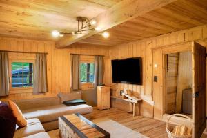 a living room with a couch and a flat screen tv at Berghaus Wiesegg - Uriges Tiroler in Fügenberg